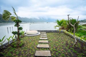 a stone walkway next to a body of water at Villa Jepun Segara Giri in Kubupenlokan +21 photos