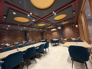 a dining room with tables and blue chairs at Eve Hotel in Varanasi