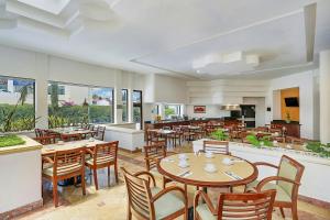 a restaurant with wooden tables and chairs and windows at Fiesta Inn Express Chihuahua in Chihuahua