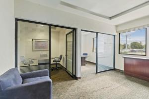 a living room with a couch and a table and glass doors at Fiesta Inn Express Chihuahua in Chihuahua