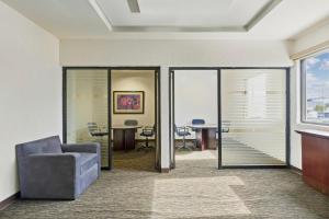 a living room with a chair and a table at Fiesta Inn Express Chihuahua in Chihuahua