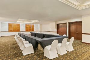a conference room with a long table and white chairs at Fiesta Inn Express Chihuahua in Chihuahua +25 photos