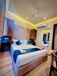a bedroom with a large bed with blue pillows at Hotel RK Heights 300M HOTEL TO GOLDEN TEMPLE in Amritsar