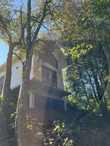 a white house with trees in front of it at Cabaña Sendero De Las Luciernagas in Zacatlán