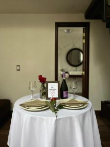 a table with two wine glasses and a white table cloth at Cabaña Sendero De Las Luciernagas in Zacatlán