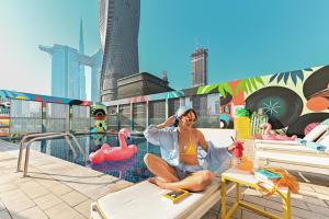 a woman sitting on a chair on a roof at Rove City Walk in Dubai