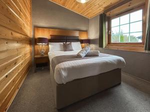 a bedroom with a large bed and a window at Lodge 2 - Uk51263 in Glasgow