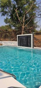 a swimming pool with a water fall in the middle at Hangout Villa in Malavli