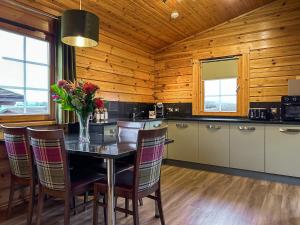 a kitchen with a table with a vase of flowers on it at Lodge 2 - Uk51263 in Glasgow +5 photos