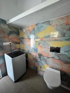 a bathroom with a rock wall with a toilet at Chamundi Temple-Hill View in Mysore
