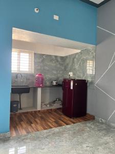 a kitchen with a purple refrigerator and a sink at Chamundi Temple-Hill View in Mysore