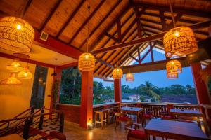 a restaurant with tables and chairs and lights at Superresidence in Balapitiya