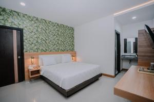 a bedroom with a large white bed and a wall at Hotel 88 Batulicin by WH in Batulicin +65 photos