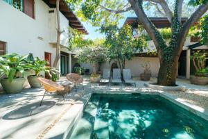 a swimming pool with chairs and a house at Welcome to Paradise - Luxurious Studio Oasis "Artemisa" with Pool and Lush Tropical Gardens in Sayulita