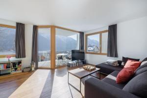 a living room with a couch and a table at Chasa AlpVista in Sent