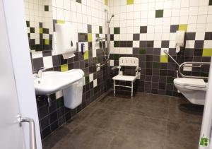 a bathroom with a sink and a toilet at Camping Houtum in Kasterlee +64 photos