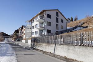 a building on a street next to a fence at Chasa AlpVista in Sent