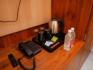 a desk with a telephone and a tea kettle and water at Hotel Nirvvana Residency in Varanasi