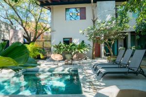 a patio with two chairs and a swimming pool at Welcome to Paradise - Luxurious Studio Oasis "Urania" with Pool and Lush Tropical Gardens in Sayulita