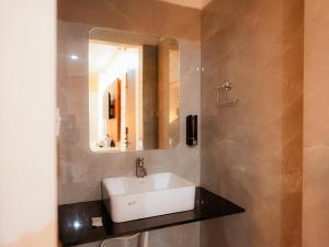 a bathroom with a sink and a mirror at Hotel Nirvvana Residency in Varanasi