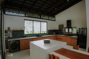 a large kitchen with a table and a window at The Villa - Premium Private Pool Villa in Vaduvanchal