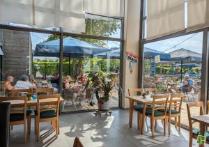a restaurant with tables and people sitting at tables at Camping Houtum in Kasterlee