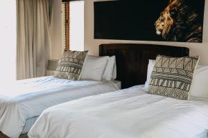a bedroom with two beds and a picture of a giraffe at 119 Zebula in Mabula