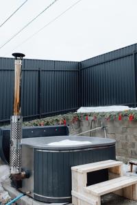 a hot tub in a backyard with a fence at Mini Хаус Ясіня in Yasinya
