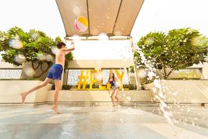 a boy and a girl playing with a volley ball in a swimming pool at Rove At The Park in Dubai +25 photos
