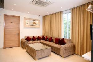 a living room with a brown couch and red pillows at Hotel Diamond Villa and Banquet in Amritsar