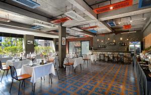 a restaurant with white tables and chairs in a room at Central Corner Suite in Siem Reap