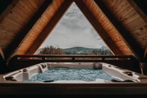 a bath tub in a cabin with a window at Lavender Hill, Eko Resort & Wellness in Polzela