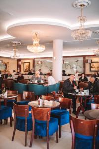 Eine Gruppe von Menschen sitzt an Tischen in einem Restaurant in der Unterkunft Hotel Bristol in Mostar