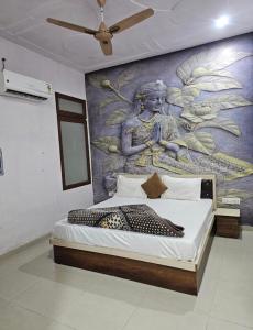 a bedroom with a mural of a woman on the wall at Hotel Shree Govind Dev and Restaurant in Khātu