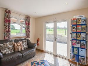 a living room with a leather couch and a sliding glass door at Oak - Glamping Pod - Uk49946 in Oswestry