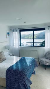 a bedroom with a bed and a large window at Sea Vista Boutique Accommodation in Fahan