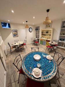 a dining room with tables and chairs and a clock at The LightHouse Chambres à louer in Châteaulin