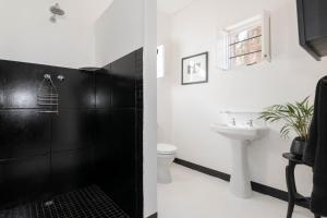 a black and white bathroom with a toilet and a sink at Temenos Retreat in McGregor +30 photos