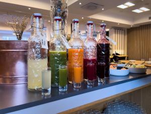 a row of bottles filled with different colored drinks at KOMPAS Hotel Aalborg in Aalborg