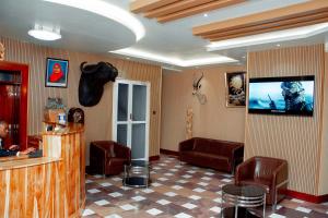 a waiting room with leather chairs and a flat screen tv at Beaco Resort in Mbeya