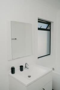 a white bathroom with a sink and a mirror at Gonubie Beachside Delight Apartment in East London +33 photos