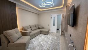 a living room with a couch and a flat screen tv at Life park Osh 2 in Osh