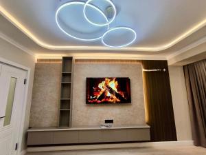 a living room with a fire on the wall at Life park Osh 2 in Osh +5 photos