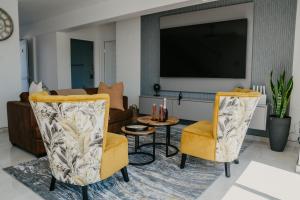 a living room with two chairs and a tv at Gonubie Beachside Delight Apartment in East London
