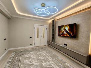 a living room with a fireplace and a painting on the wall at Life park Osh 2 in Osh
