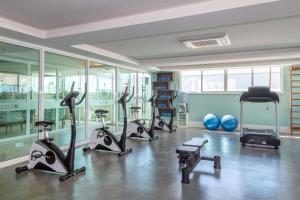 un gimnasio con varias cintas de correr y bicicletas estáticas en Flat Macaé, en Macaé