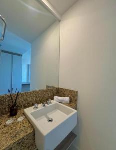 un baño con un lavabo blanco y un espejo en Flat Macaé, en Macaé 7 fotos más