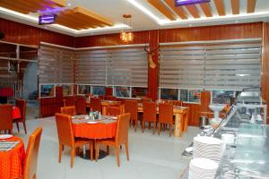 a dining room with tables and chairs and windows at Beaco Resort in Mbeya