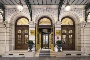 a lobby of a building with two doors and some plants at Hilton Paris Opera in Paris
