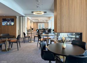 a restaurant with tables and chairs and a fireplace at KOMPAS Hotel Aalborg in Aalborg